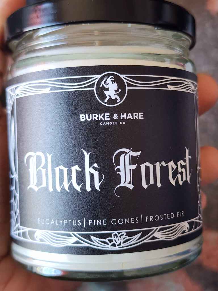 ID: a clear jar candle from Burke & Hare called Black Forest, with notes of eucalyptus, pine cones, and frosted fir