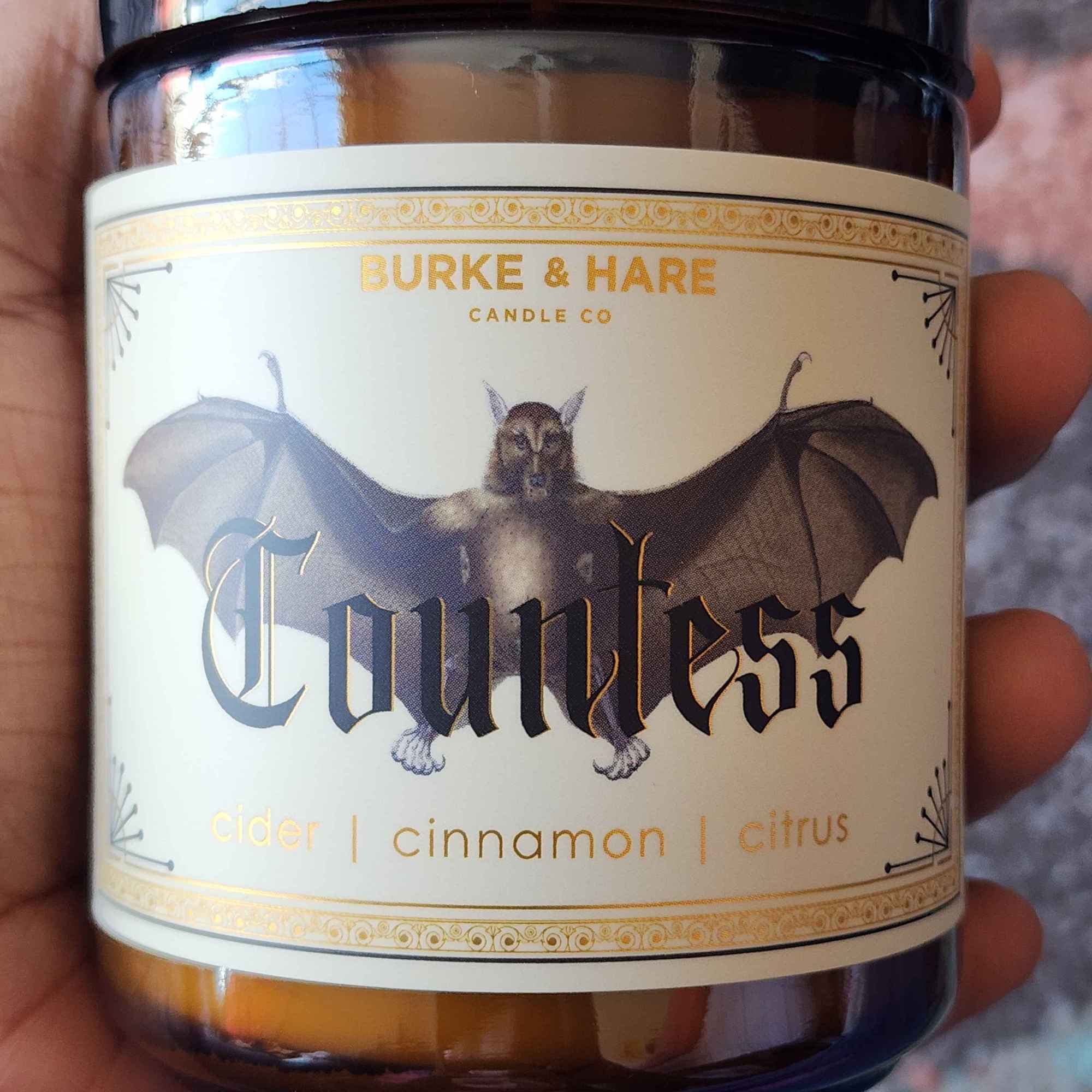 ID: an amber jar candle from Burke & Hare called Countess, with notes of cider, cinnamon, and citrus.