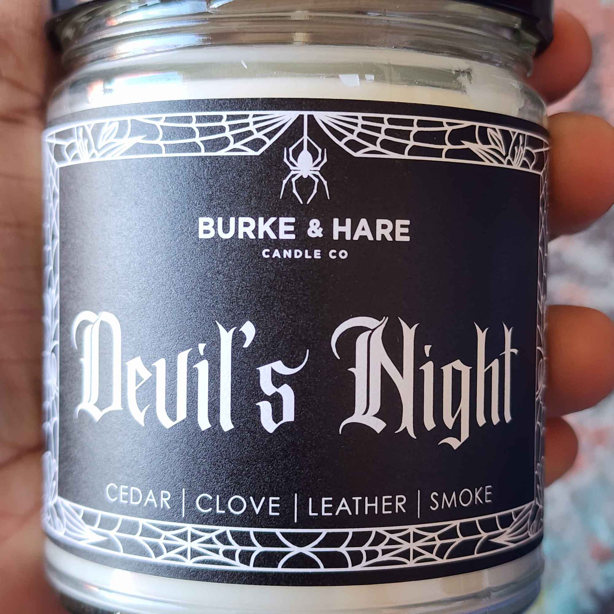 ID: a clear jar candle from Burke & Hare called Devil's Night. it has notes of cedar, clove, leather, and smoke 