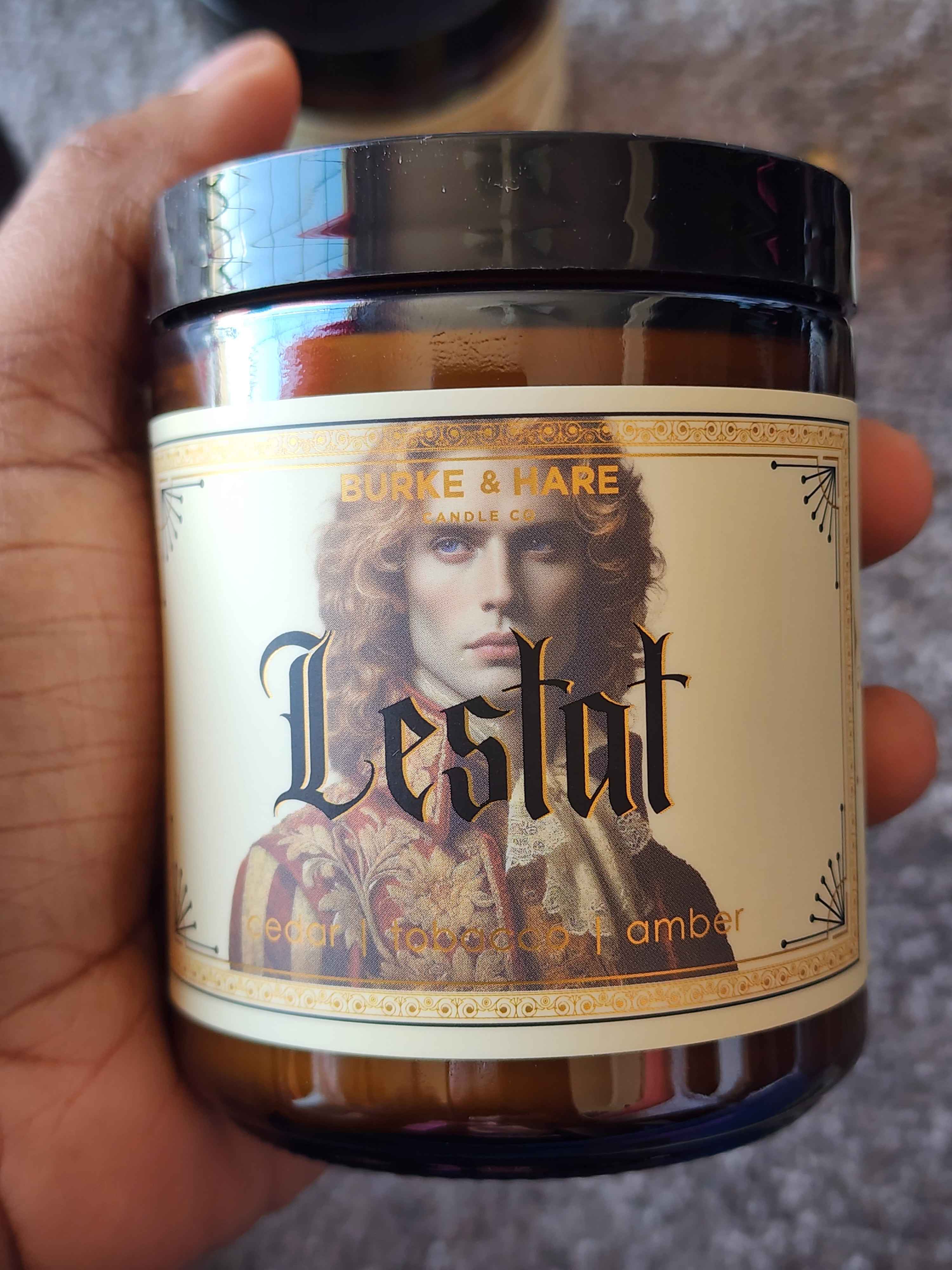 ID: an amber jar candle from Burke &n Hare called Lestat, with notes of cedar tobacco, and amber