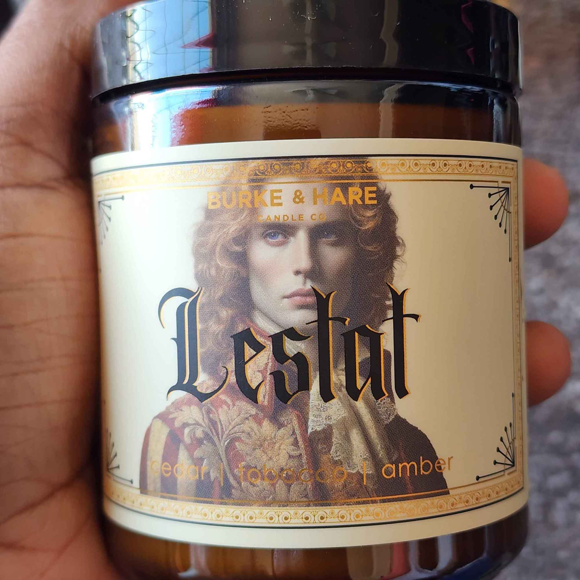ID: an amber jar candle from Burke &n Hare called Lestat, with notes of cedar tobacco, and amber