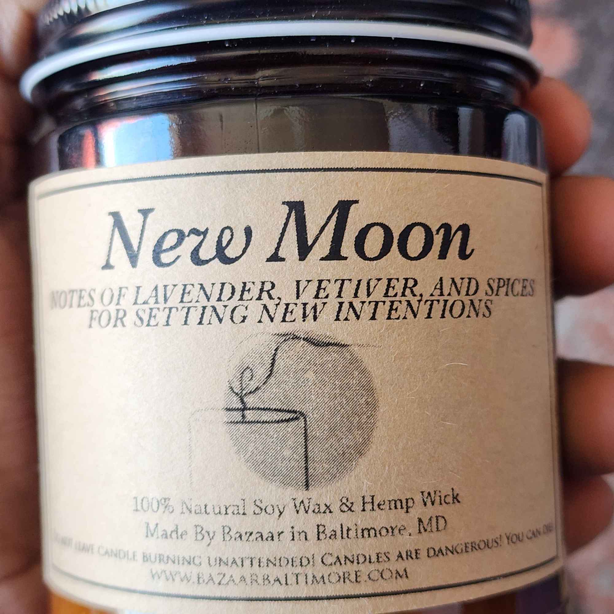 ID: an amber jar candle from Bazaar  in Baltimore called New Moon. it has notes of lavender, vetiver, and spices for setting new intentions